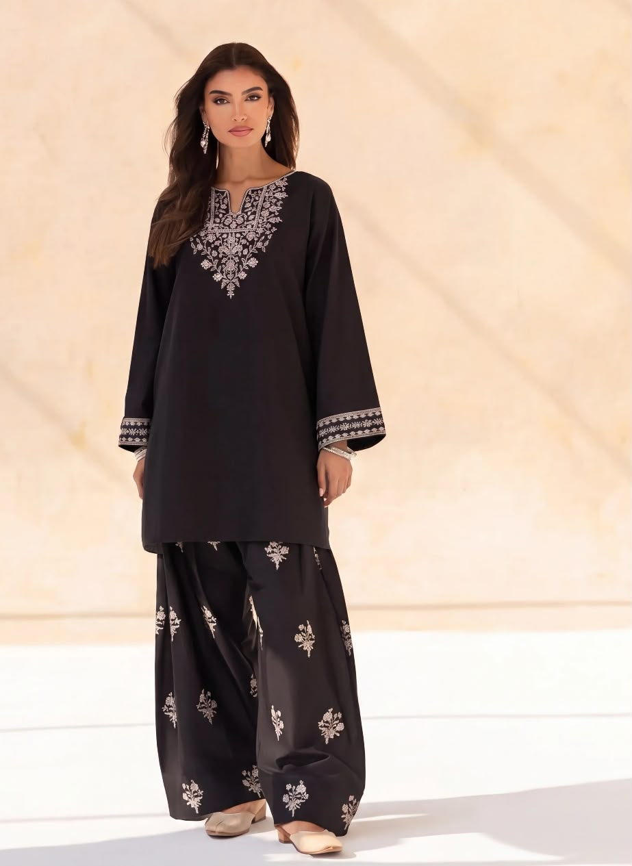 Black two-piece suit with light floral detailing on the neckline, cuffs and wide-leg trousers